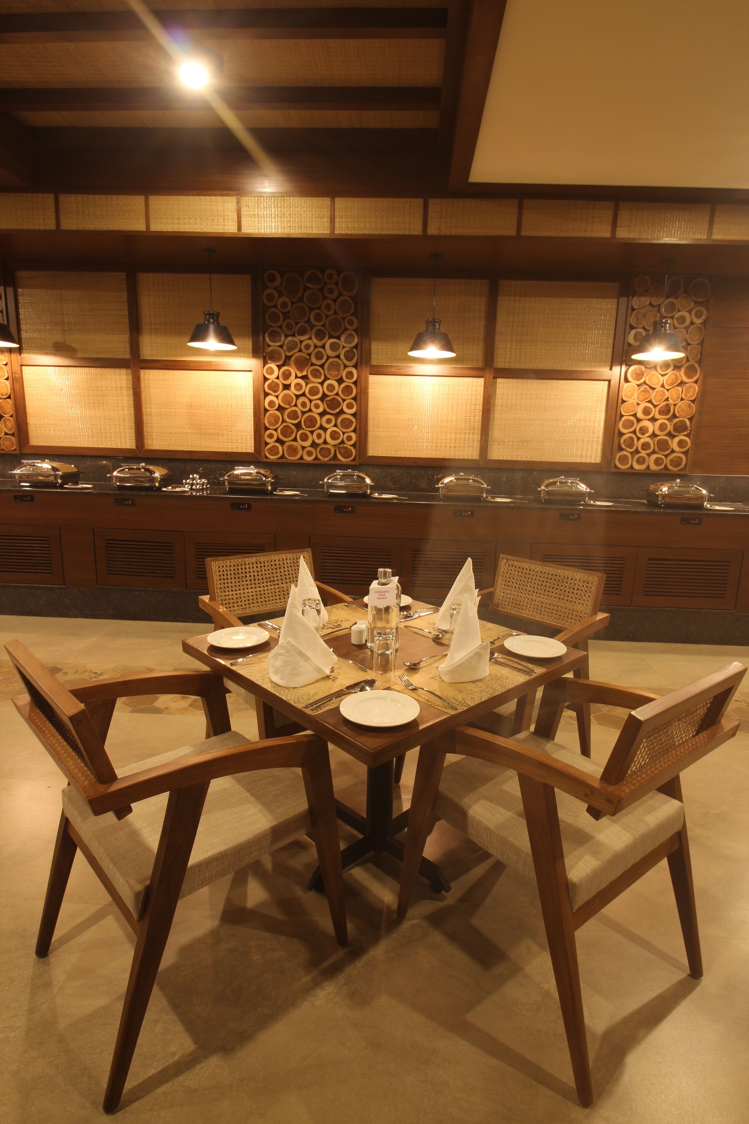 Un comedor con una mesa de madera dispuesta para cuatro personas, rodeado de sillas.