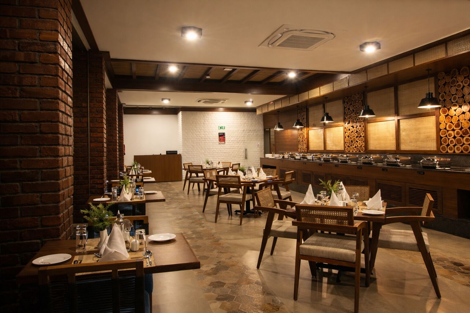 A restaurant with brick walls, wooden tables, and a buffet area.
