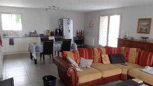 A living room with a sofa, a coffee table, and a dining area with chairs and a table. - Villa near village center (Pradelles)