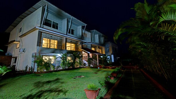 A two-story house with a well-maintained lawn and potted plants. - Treebo Paradise Inn, Panchgani (Mahabaleshwar)