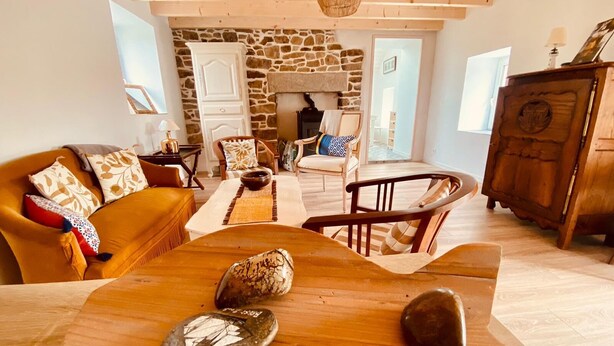 Ein gemütliches Wohnzimmer mit Kamin aus Stein, Holzmöbeln und rustikalem Stil.