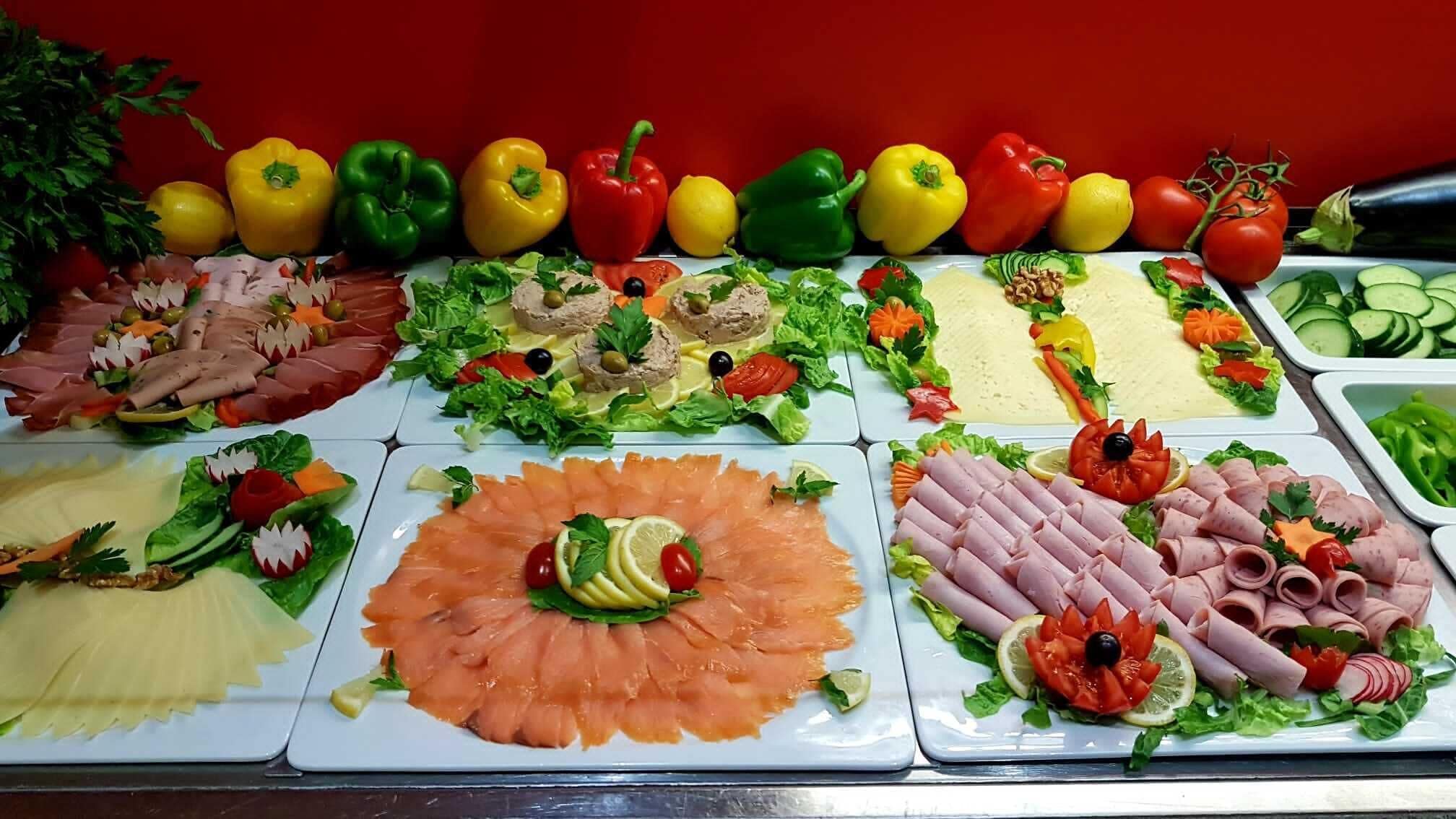 A buffet with various food items including meats, salads, and vegetables.
