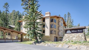 A multi-story building with a stone base and a beige upper section, featuring a sign that reads "Silver Bear." - Bright Upgraded Modern Wash/Dryer Near Bike & Walking Trails Pool On-site (Mammoth Lakes)