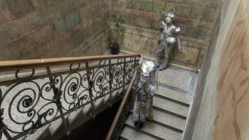 A staircase with ornate metal railings and a statue.