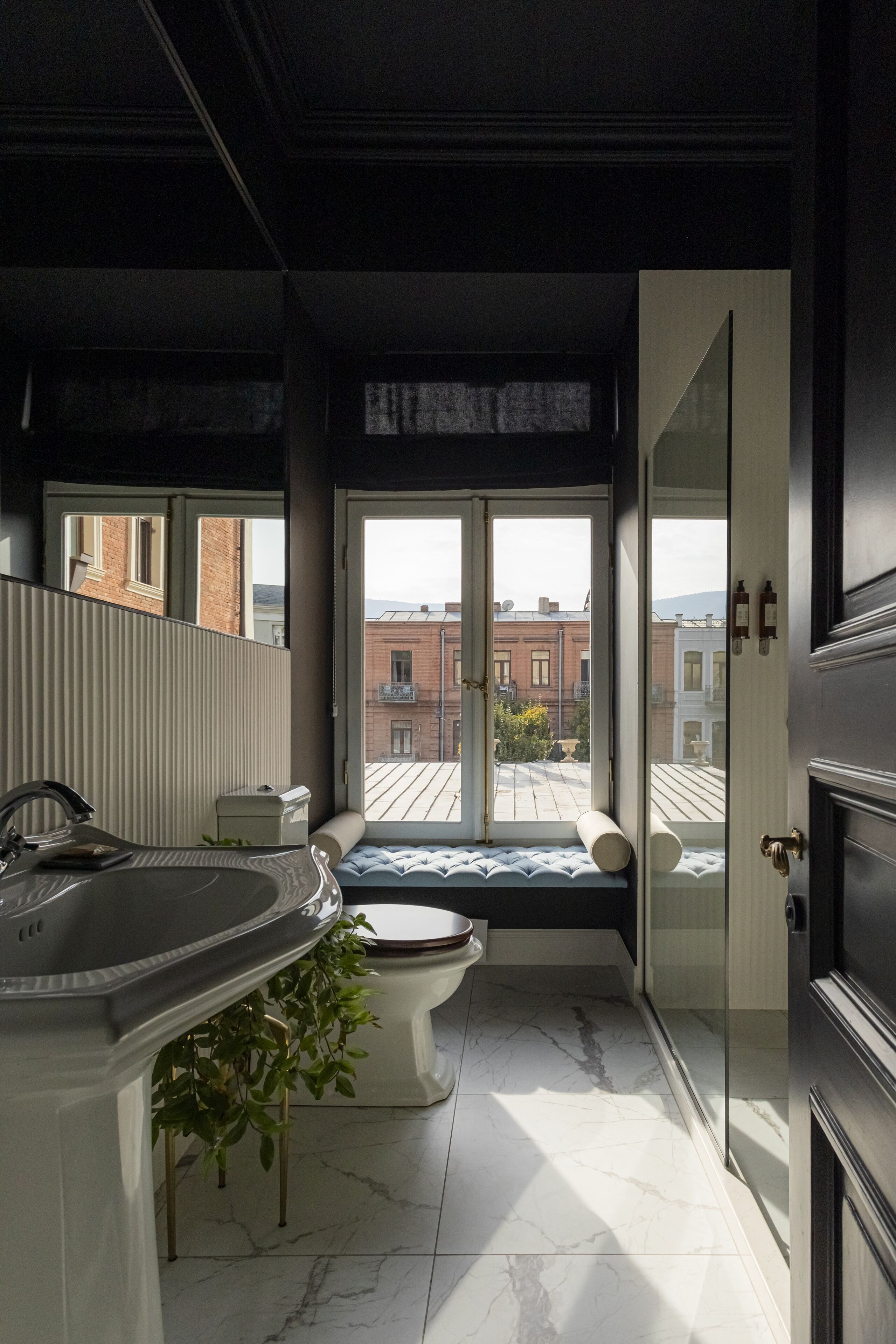 Un baño moderno con un ventanal grande, una bañera y un lavabo.