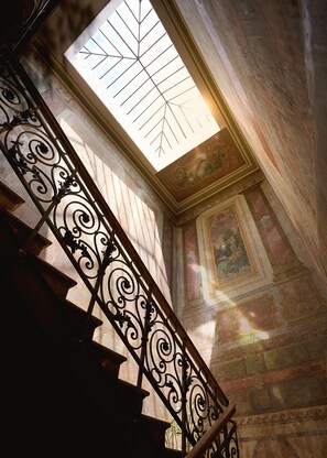 A staircase with ornate metal railings and a skylight. - Unfound Door (Tbilisi)