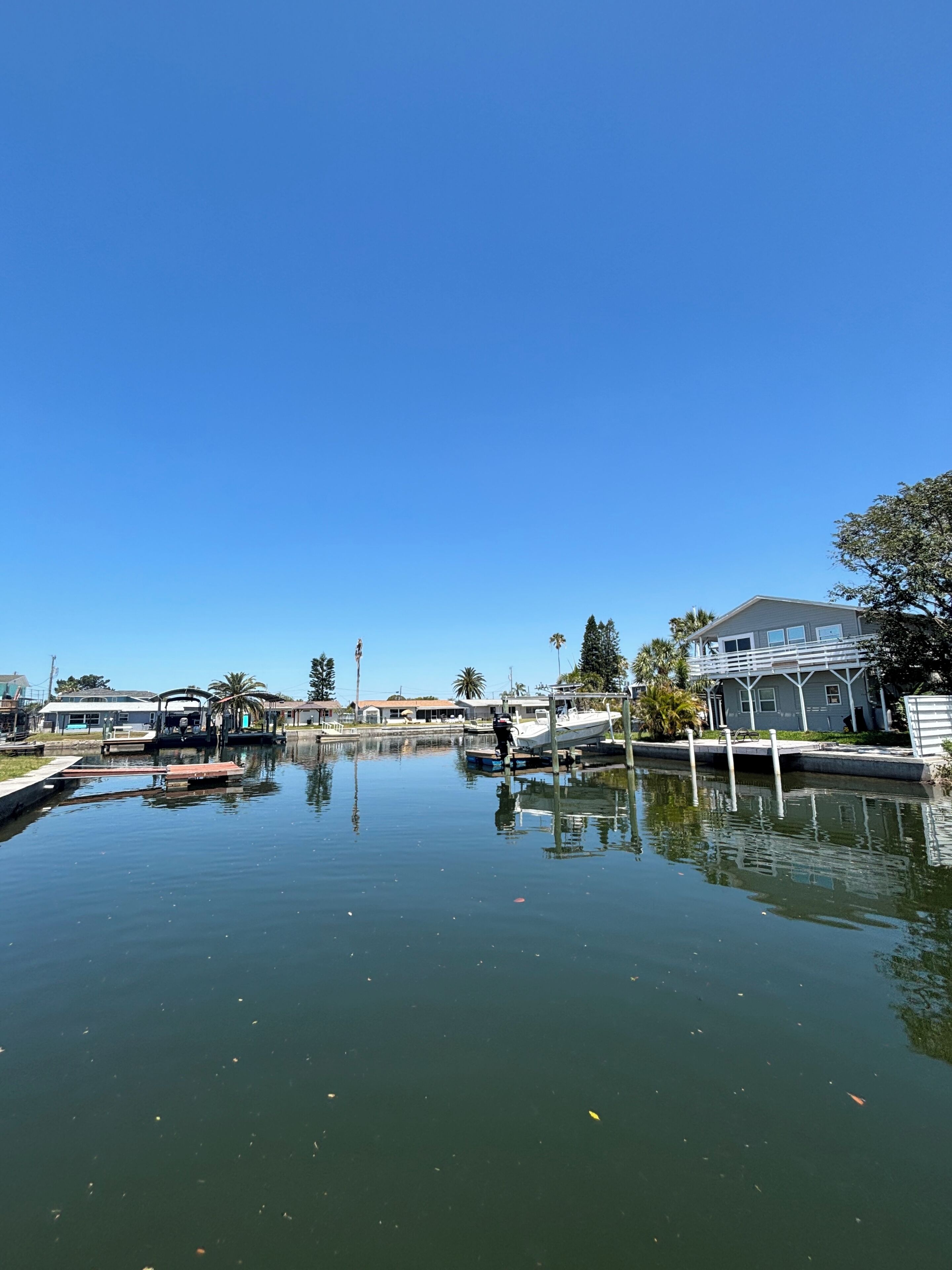 Un port de plaisance où l’eau est calme, où les bateaux sont amarrés et où le ciel est d’un bleu limpide.