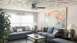 A living room with a sectional sofa, a coffee table, and a ceiling fan. - Seminole Comfort: Private Pool Home - 3BD/2BA (Private Homes)