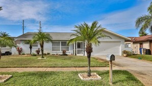 A single-story house with a garage, a front yard with palm trees, and a mailbox. - Seminole Comfort: Private Pool Home - 3BD/2BA (Private Homes)