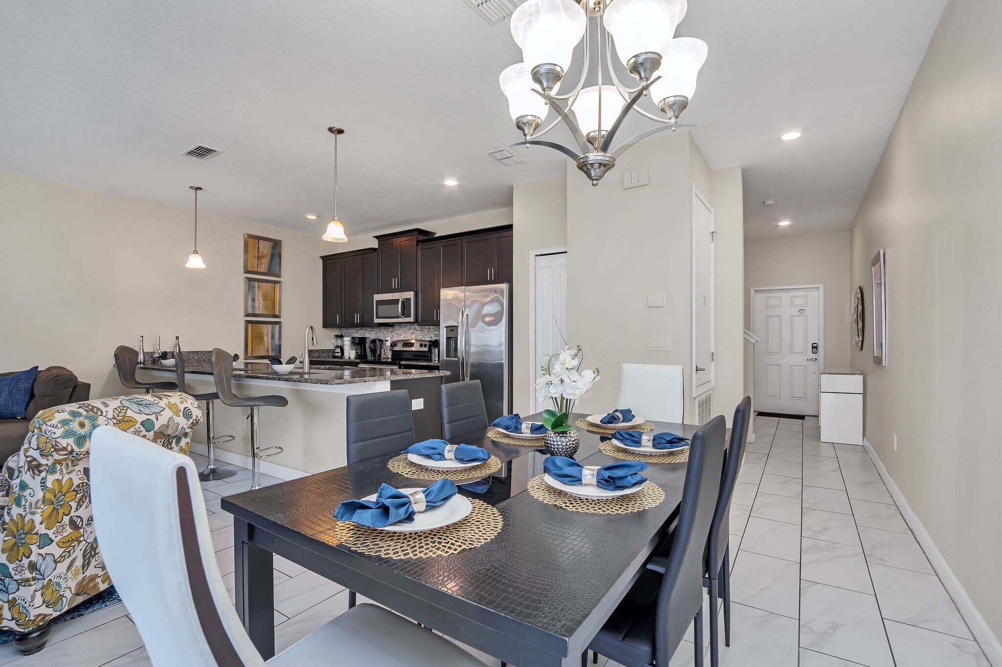 A modern kitchen with dark cabinets, a microwave, and a refrigerator.