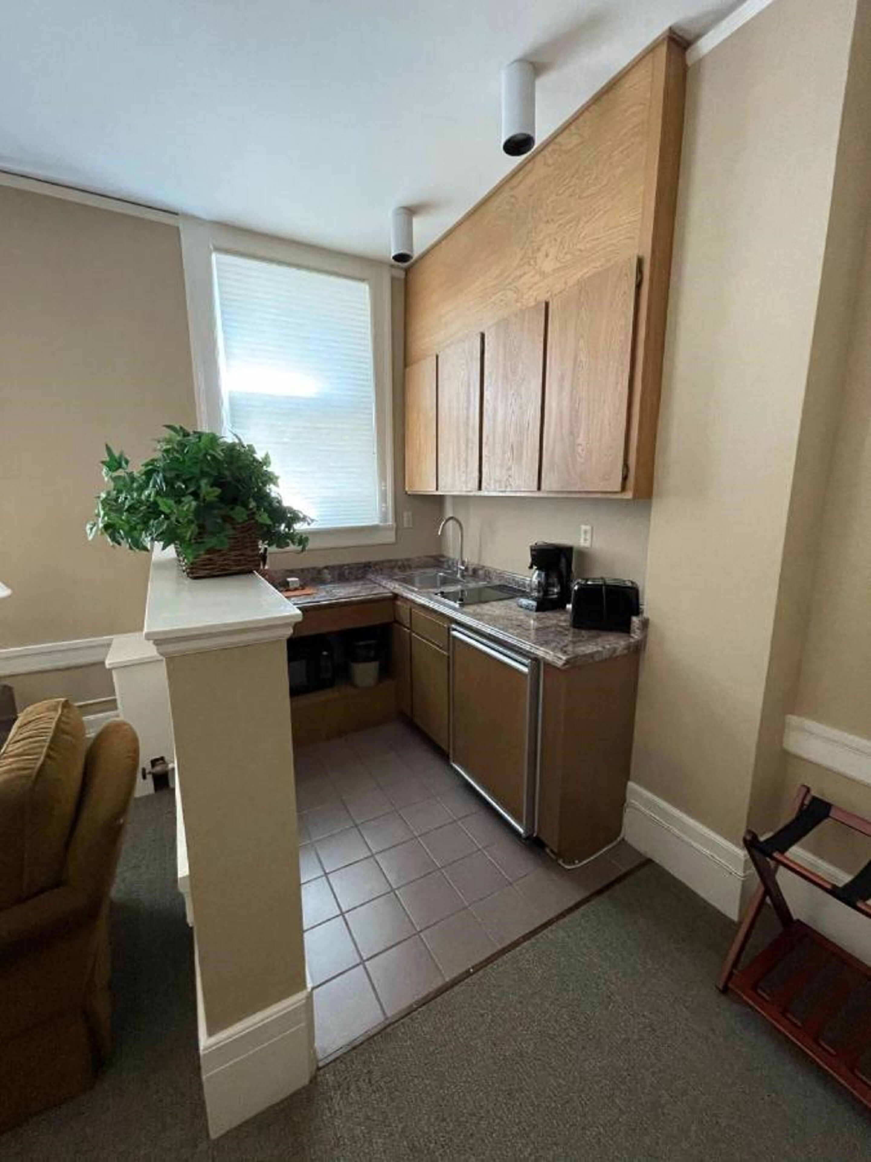 A compact kitchen with wooden cabinets, a built-in sink, and a countertop.