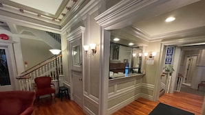 A hallway with a staircase, a mirror, and a door leading to a bathroom. - Powell Place at Nob Hill (San Francisco)