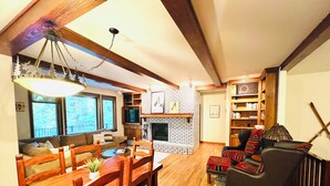 A cozy living room with a fireplace, wooden furniture, and a television.
