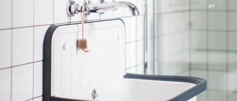 A bathroom with a white sink, a mirror, and a glass shower enclosure.