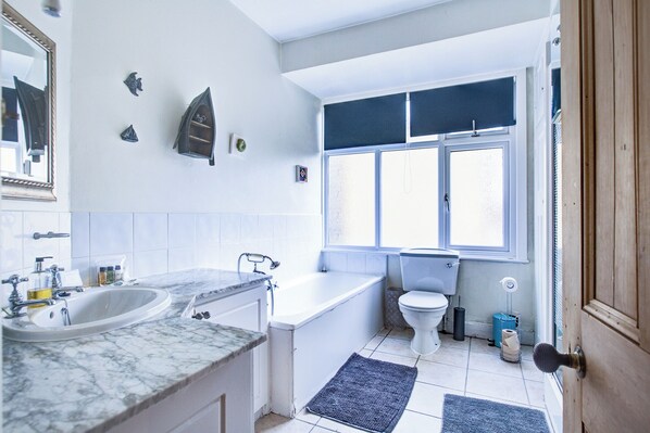 Un baño con bañera, inodoro y lavamanos.