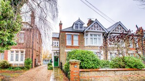 A traditional brick house with a green door, a brick wall, and a small garden. - Entire 1bed Studio With Ensuite, Balcony & Parking (Westcliff-on-Sea)