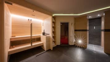 A modern spa room with a wooden sauna, a glass shower enclosure, and a red-tiled floor.