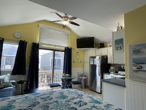 A compact kitchen with a refrigerator, stove, and dining area.