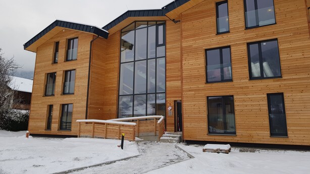 Un edificio moderno in legno con ampie finestre e tetto piano.