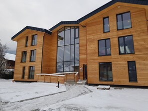 A modern wooden building with large windows and a flat roof.