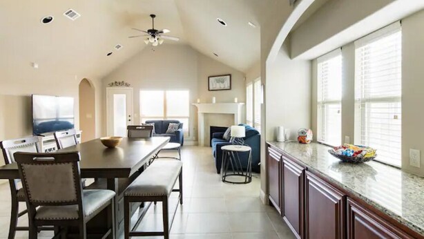 A spacious kitchen with a dining area, a fireplace, and a large window providing natural light.