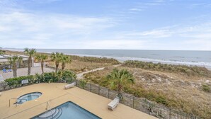 Zona de piscina con vista a la playa y al océano.