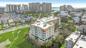 A high-rise hotel with multiple floors, a swimming pool, and a river running through the property.