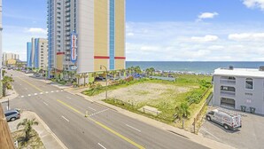 A coastal hotel with a beach view, a parking lot, and a road leading to the beach. - Ocean Terrace I D3-2BR/2BA Condo in Cherry Grove (North Myrtle Beach)