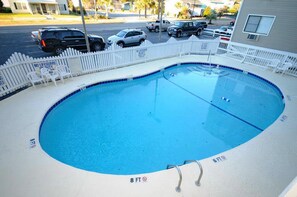 A round swimming pool with a white fence, 8 FT depth markings, and a ladder.