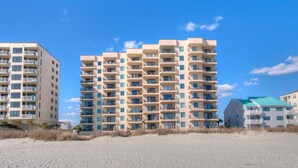 A beachfront hotel with multiple floors, balconies, and a sandy beach in the foreground. - Tidemaster 402-3BR/3BA Oceanfront condo in Ocean Drive (North Myrtle Beach)
