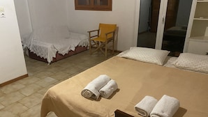 A bedroom with a bed, two rolled towels, a chair, and a window. - Cosy Calm Cottage in Olive Trees With sea View (Ermionida)