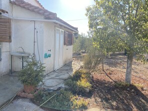 A house with a tiled roof, a small sink, and a potted plant in the yard. - Cosy Calm Cottage in Olive Trees With sea View (Ermionida)