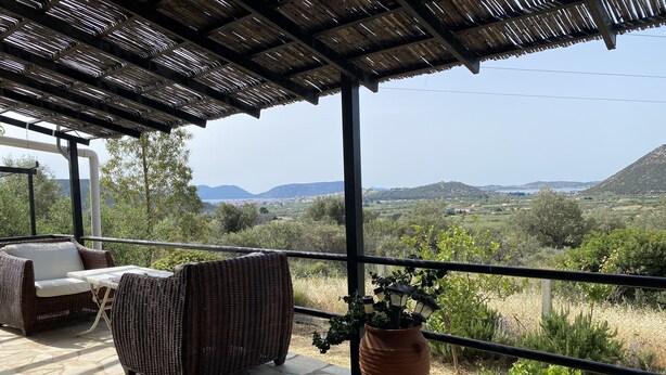 A covered outdoor seating area with wicker furniture and a potted plant. - Cosy Calm Cottage in Olive Trees With sea View (Ermionida)