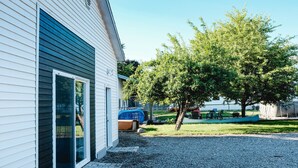 A house with a gravel driveway, a tree, and a blue canoe. - Beautiful new guest cottage, perfect for families! (Hayden)