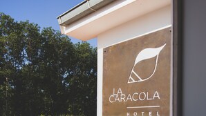 A sign for La Caracola Hotel with a leaf logo. - Hotel la Caracola Suances (Suances)