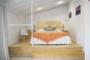 A bedroom with a wooden bed, a nightstand, a chair, and a desk. - Hotel la Caracola Suances (Suances)