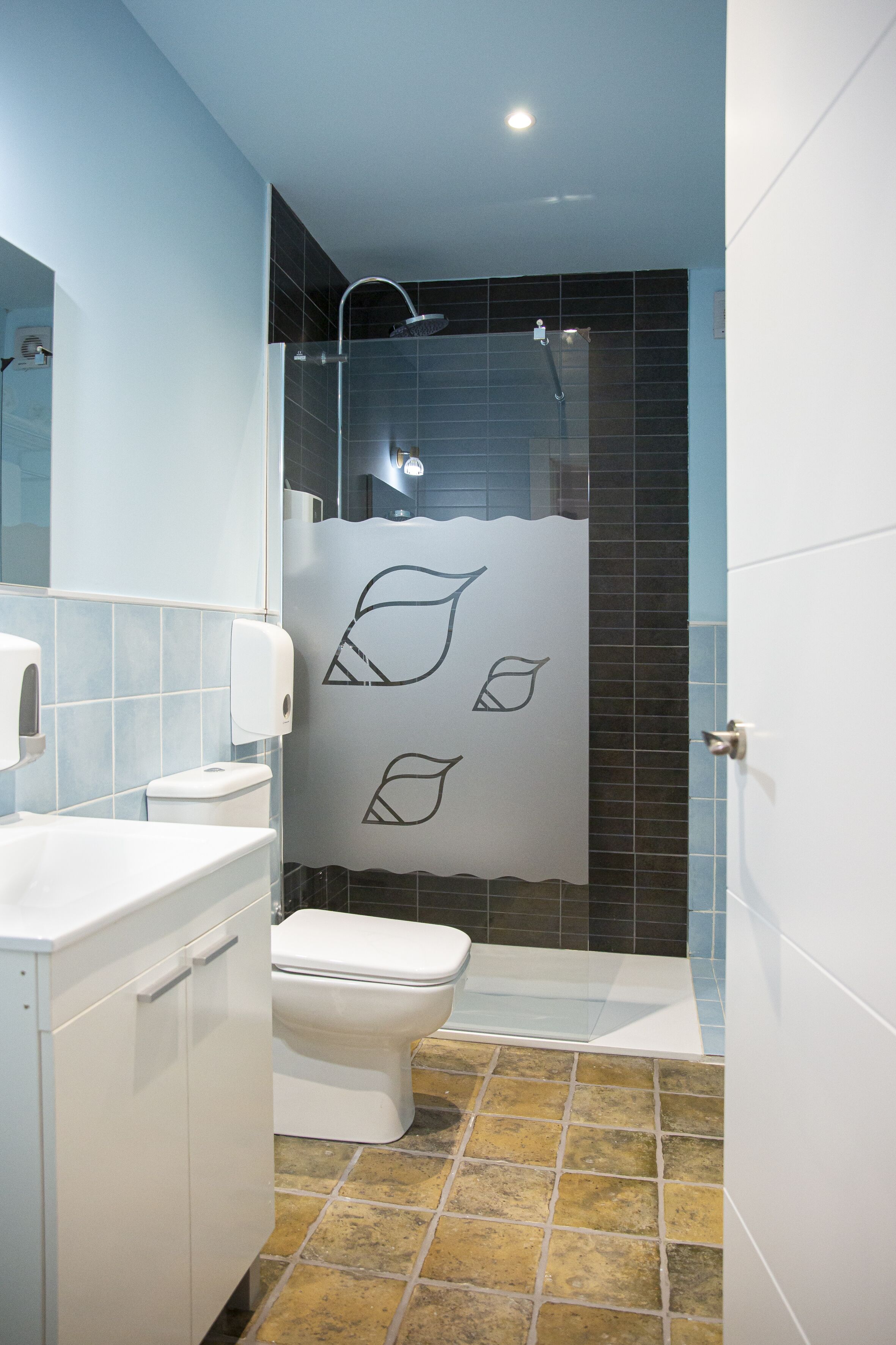 A modern bathroom with a shower, toilet, and sink.