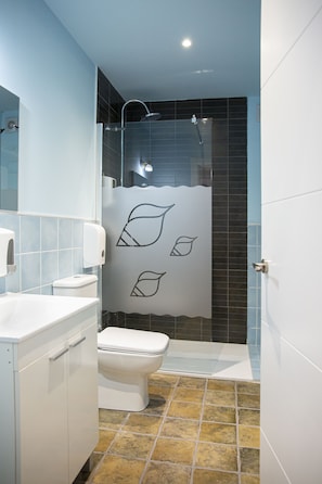 A modern bathroom with a shower, toilet, and sink. - Hotel la Caracola Suances (Suances)
