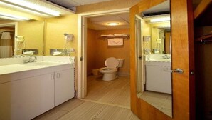 Et badeværelse med toilet, vask og spejl.