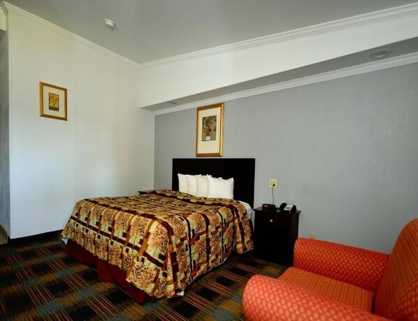 A hotel room with a bed, a nightstand, and a chair. - River-view Room, 1 King Bed with Jacuzzi tub and Balcony (Somerset)
