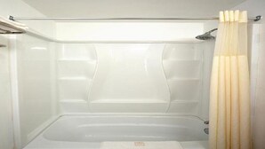 Une salle de bain moderne équipée d’une baignoire, d’une douche et d’un porte-serviettes.