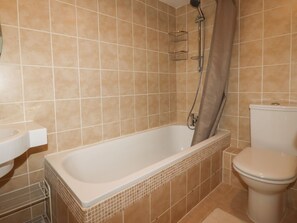 A bathroom with a bathtub, toilet, and sink. - 7 Europa Court (Newquay)
