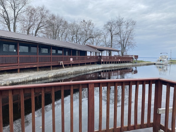 A waterfront building with a wooden deck and a boat dock. - Fishermen's Delight (Constantia)
