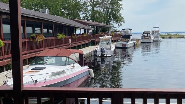 A waterfront restaurant with boats docked in the background.