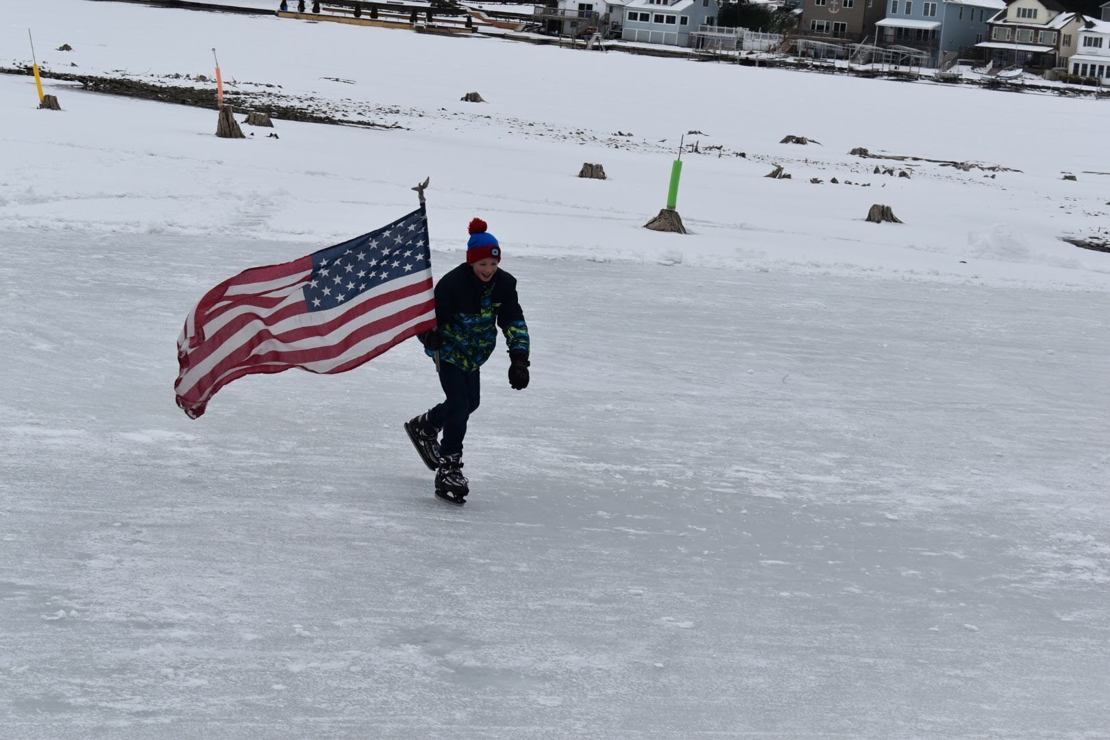 Une personne patine sur une surface enneigée, brandissant un drapeau américain.
