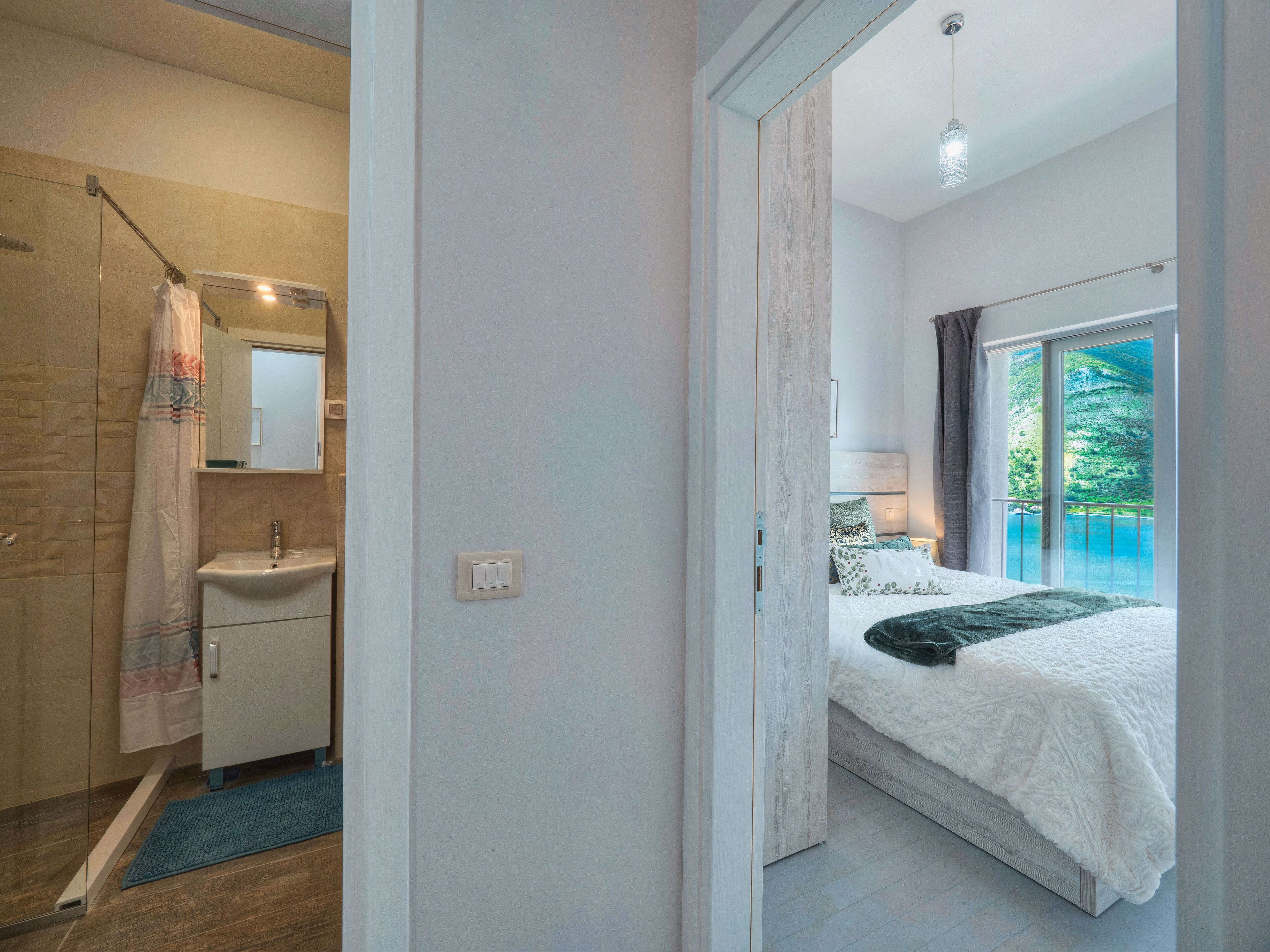 Una camera da letto con un letto grande, un bagno con doccia e vista sull'esterno.