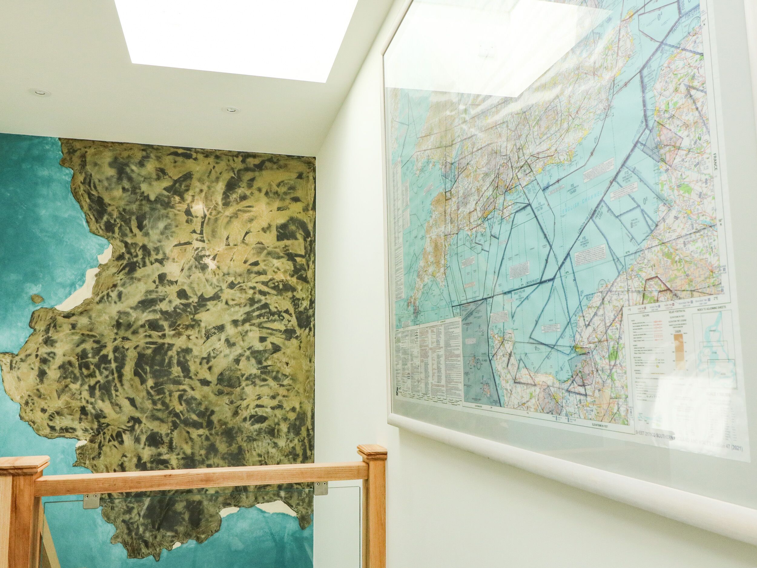 Une carte et une œuvre d’art à texture particulière sont accrochées au mur.
