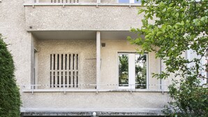 Een gebouw met twee verdiepingen, met een gevel van natuursteen, nummer 26, voorzien van een houten deur en ramen, en een fiets die ervoor geparkeerd staat.