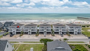 A beachfront hotel with multiple-story buildings, a pier in the background, and a beach in the distance. - "Waters Edge 427-B" - Oceanfront Condo w/ Community Pool, 2 Bedrooms / 2 Bathrooms (Holden Beach)