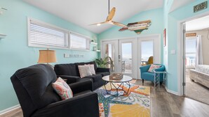 A living room with a ceiling fan, a sofa, a coffee table, and a patterned rug. - "Waters Edge 435-A" - Oceanfront Condo w/ Community Pool, 2 Bedrooms / 2 Bathrooms (Holden Beach)